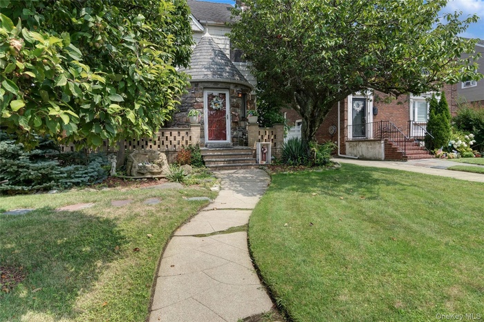 View of front of house with a front yard and stone siding