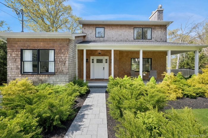 View of front of property featuring a chimney and a porch