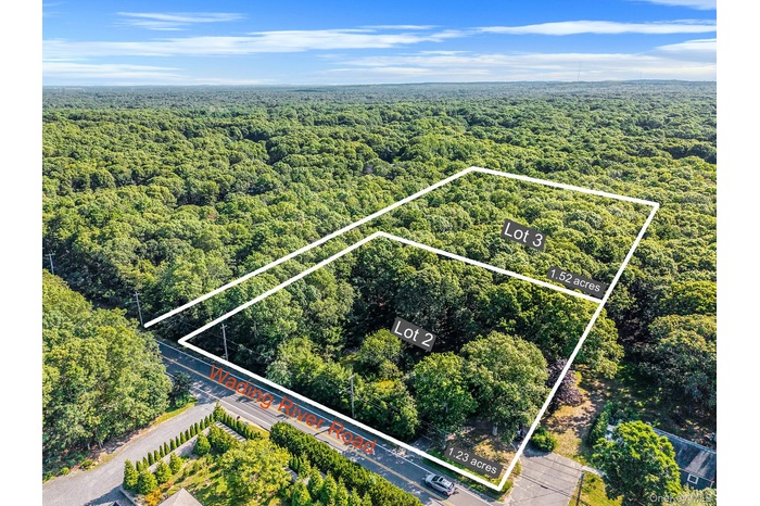 Aerial view of property and surrounding area featuring property boundaries highlighted and a forest