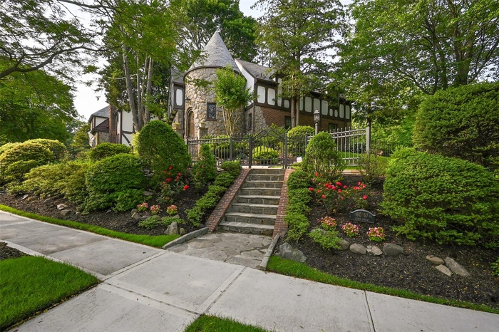 English style home featuring brick siding, stairway, and stone siding