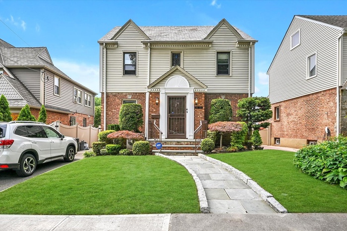 View of front facade with brick siding and a front yard