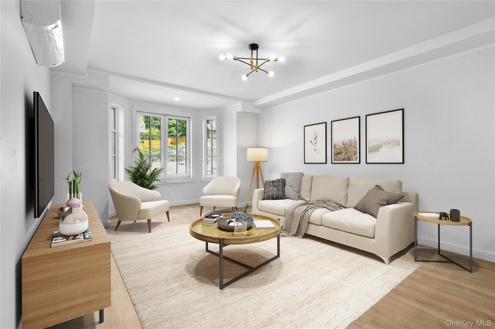 Living area featuring a chandelier, light wood-style flooring, and an AC wall unit