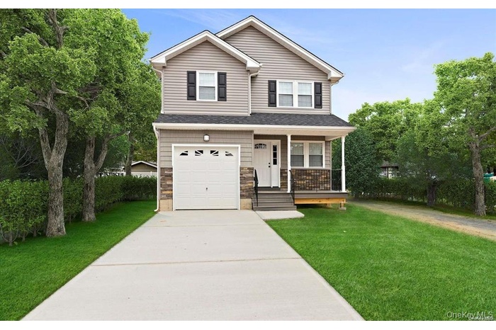 View of front of home with concrete driveway, a front lawn, an attached garage, stone siding, and a porch
