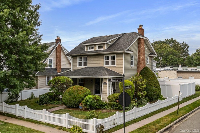 View of front of house with roof with shingles, a chimney, and a fenced front yard