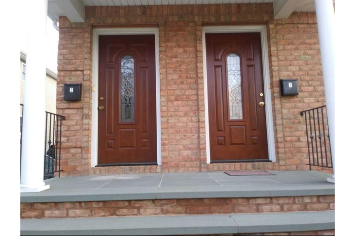 Property entrance featuring brick siding