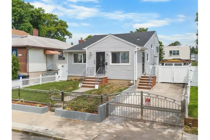 Bungalow-style house featuring a gate, a fenced front yard, and a chimney