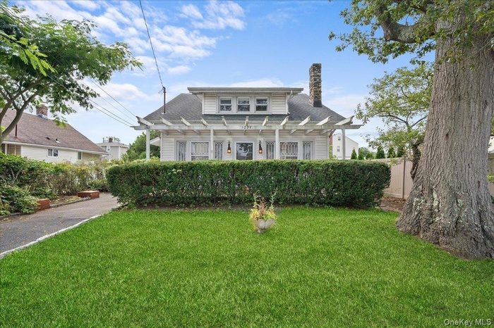Bungalow-style home featuring a chimney and a shingled roof