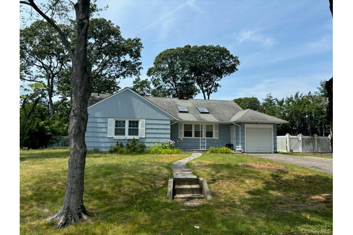 Single story home with a garage, driveway, and a chimney