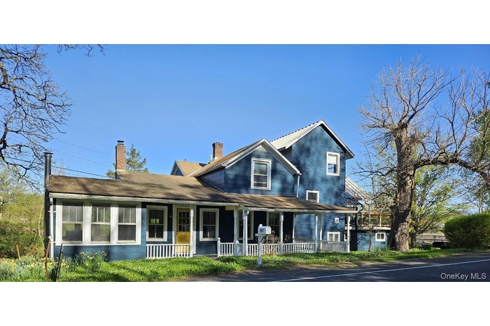 View of front of property featuring covered porch and a chimney