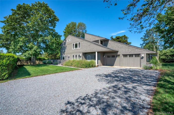 View of front facade featuring driveway and an attached garage