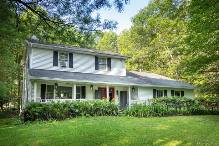 Traditional home featuring a front lawn and covered porch