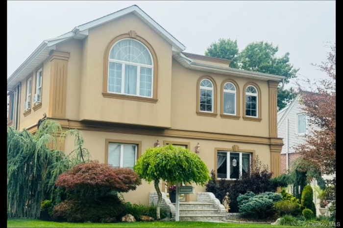 View of front of property with stucco siding and a front yard