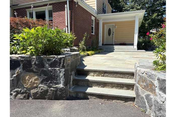 Doorway to property with brick siding and a patio area