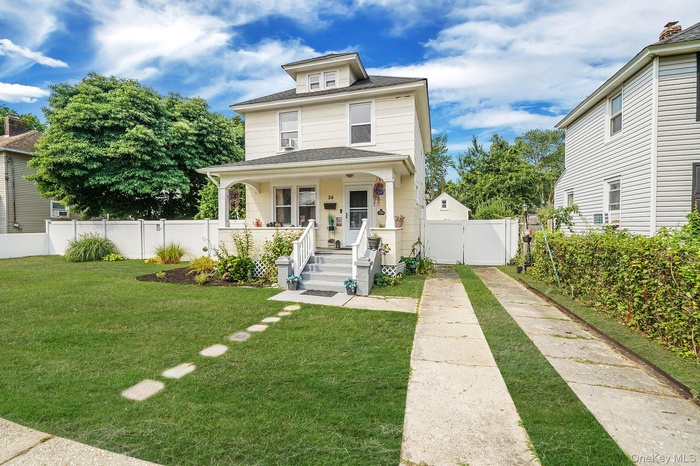 American foursquare style home with covered porch, a gate, and a shingled roof