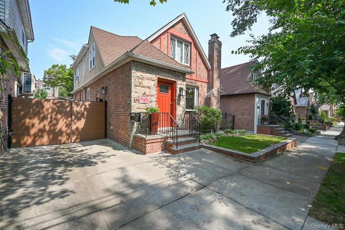 English style home with brick siding, a chimney, and roof with shingles