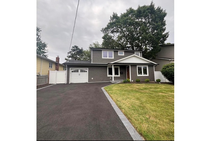 Traditional home featuring a garage and driveway