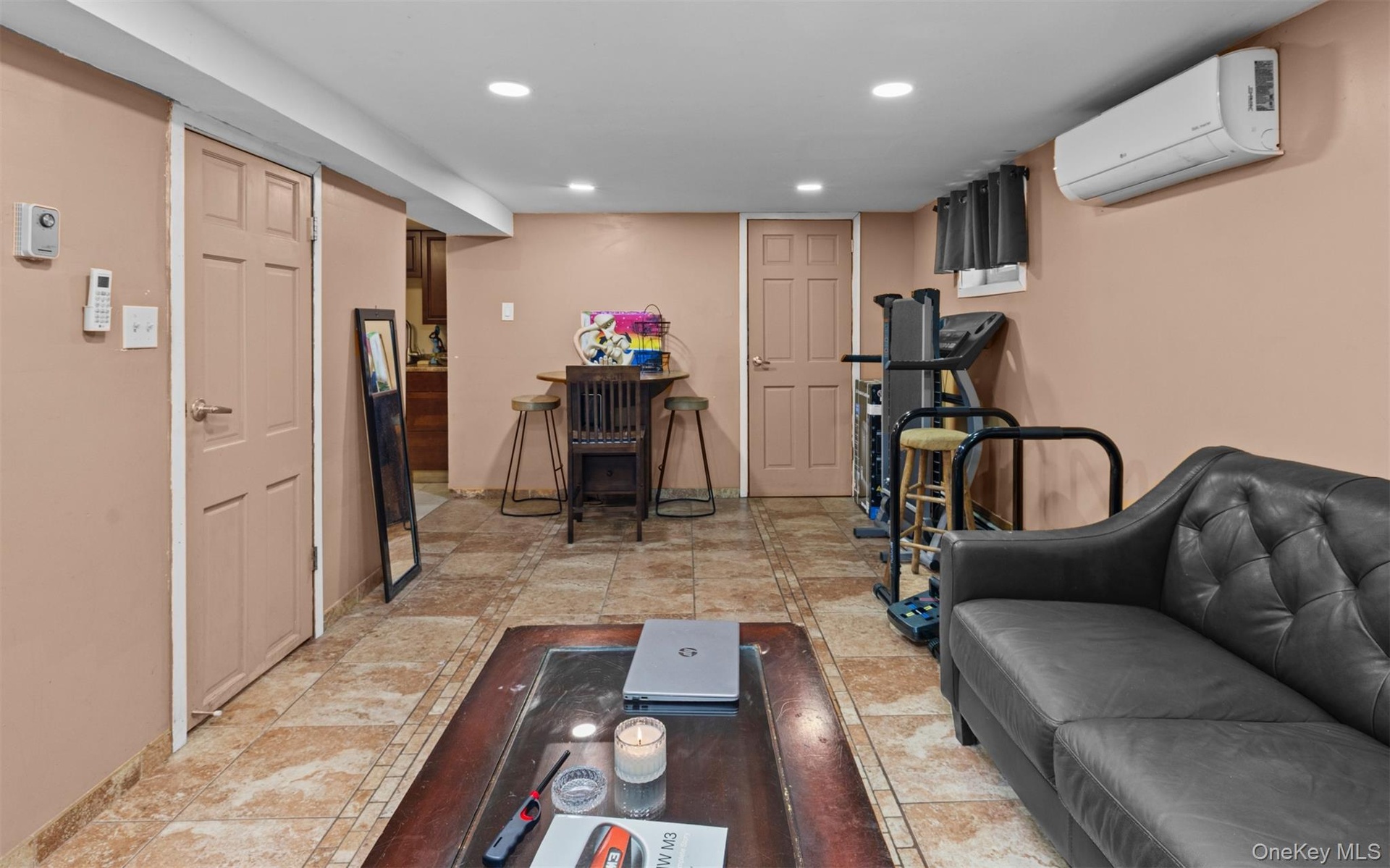 Living room with recessed lighting, a wall unit AC, and light tile patterned floors