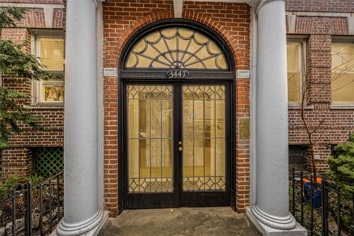 Property entrance with brick siding and fence