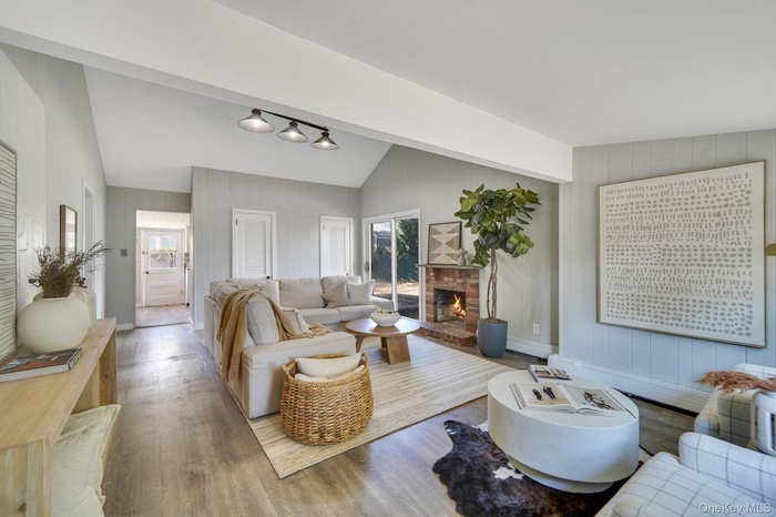 Living area with wood finished floors, wooden walls, and a fireplace