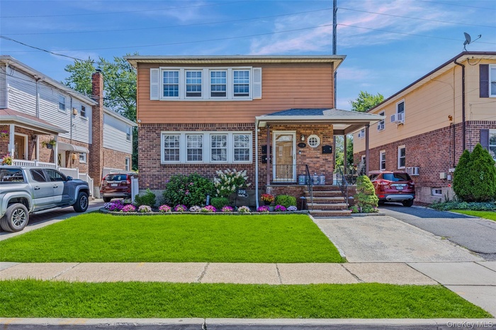 View of front facade with brick siding and a front lawn