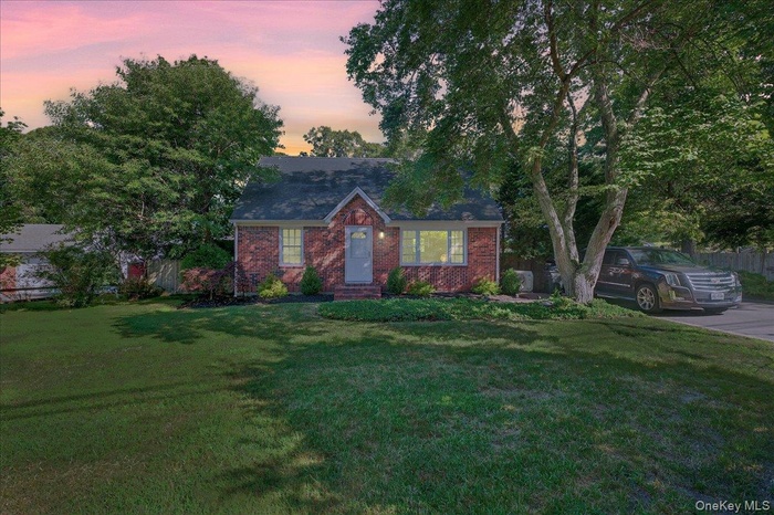 View of front facade featuring brick siding and a front lawn