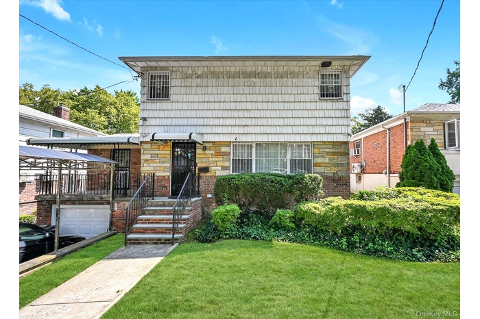 View of front of house featuring stone siding and a front yard