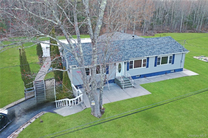 View of front facade featuring a front yard and roof with shingles