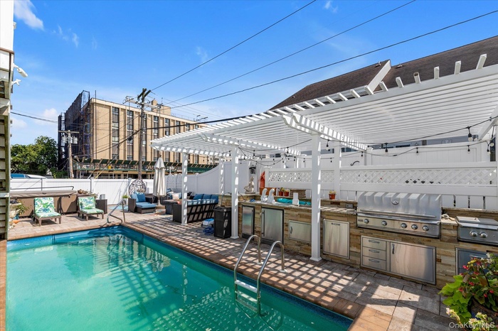 View of pool with a fenced backyard, a pergola, area for grilling, and a patio