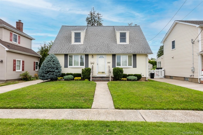 View of front of home with roof with shingles and a front yard