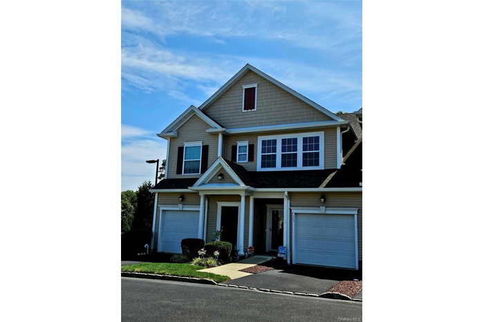 View of front facade featuring an attached garage and driveway