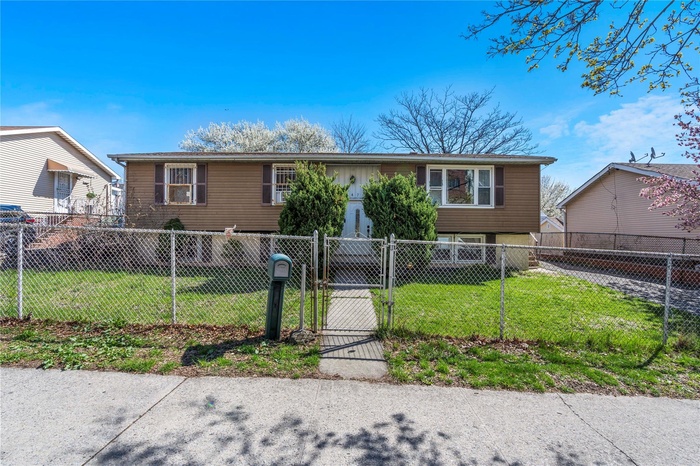 View of front of property featuring a front yard, a gate, and a fenced front yard