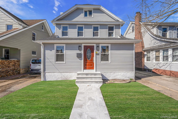 View of front of house with a shingled roof and a front yard