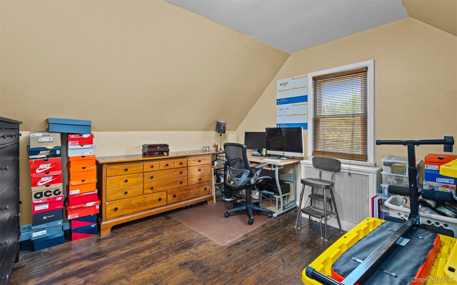 Home office featuring vaulted ceiling and dark wood finished floors