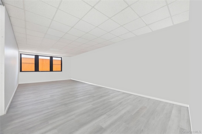 Spare room featuring light wood-style floors and a paneled ceiling