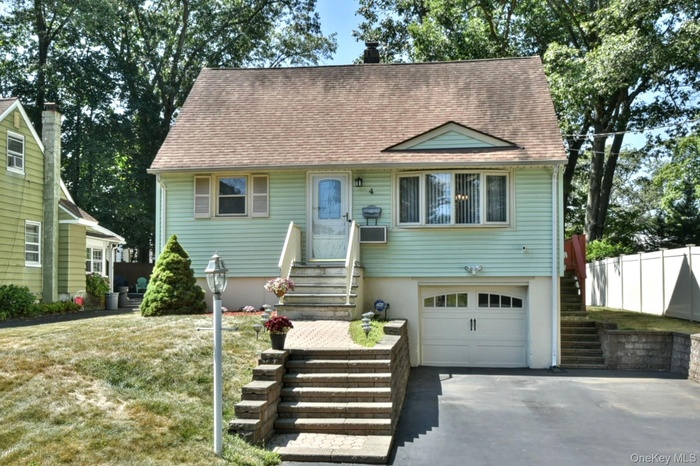 View of front facade featuring an attached garage, stairs, asphalt driveway, and roof with shingles