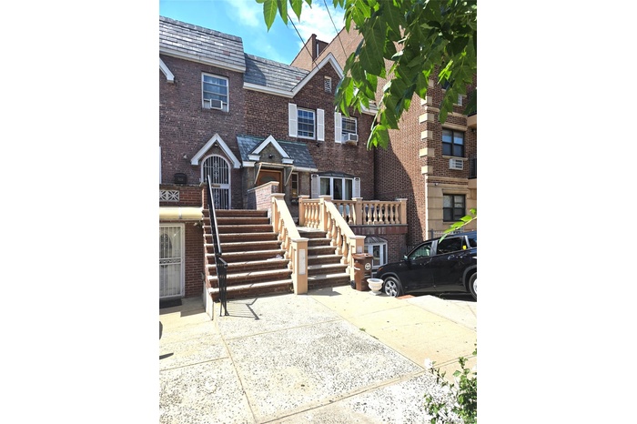 Traditional-style home featuring brick siding, a high end roof, and stairs