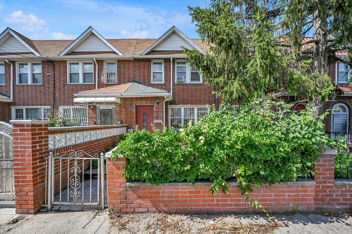 View of front facade featuring brick siding and a gate
