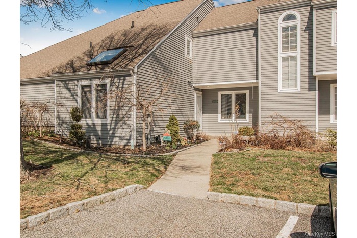 View of front of home featuring a front yard and a shingled roof