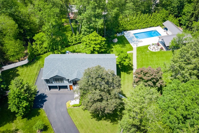 Aerial view of property and surrounding area featuring a pool area