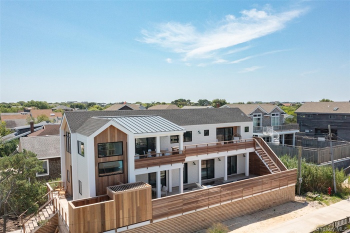 Rear view of house with a residential view, stairway, a standing seam roof, and a metal roof