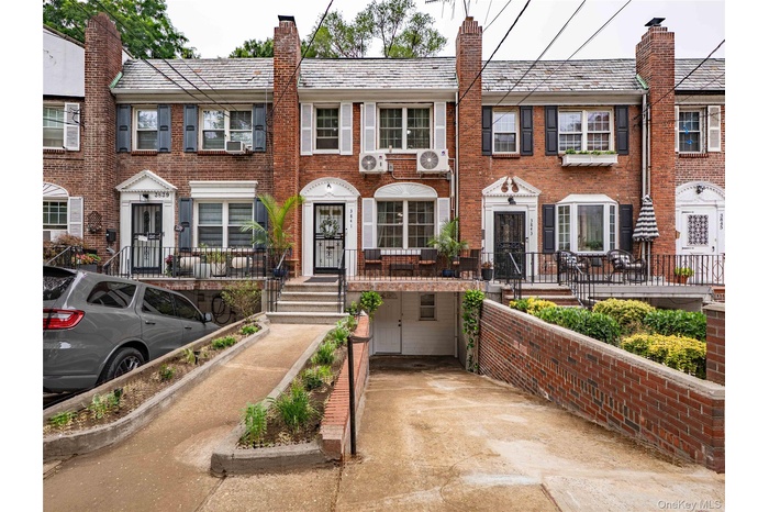 Colonial home with brick siding, a high end roof, and a chimney