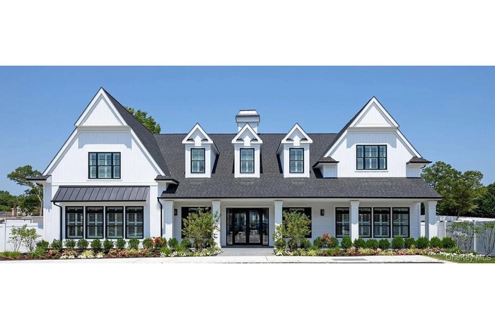 View of front of home featuring a porch, a chimney, roof with shingles, a standing seam roof, and a metal roof