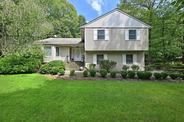 Split level home with a front lawn