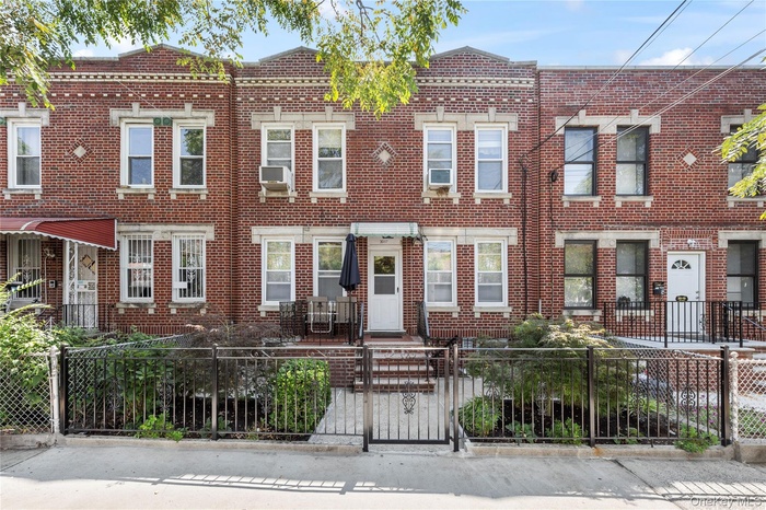 View of front of property featuring a gate, brick siding, and a fenced front yard