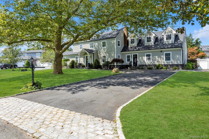 View of front of property featuring a front lawn and driveway