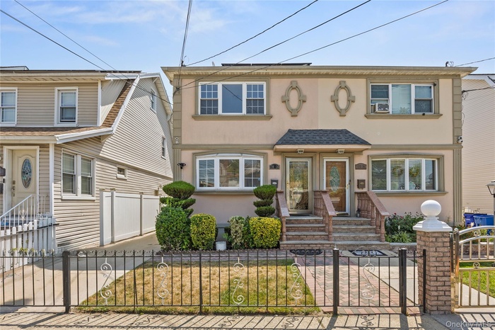 View of front facade featuring a gate, stucco siding, and a fenced front yard