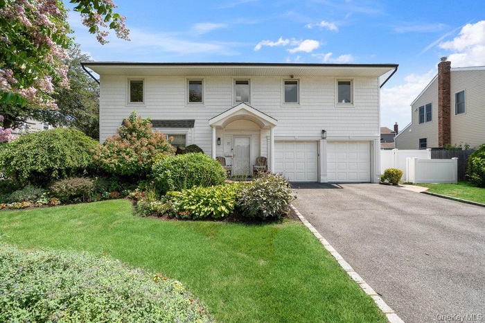 View of front of property featuring an attached garage and driveway