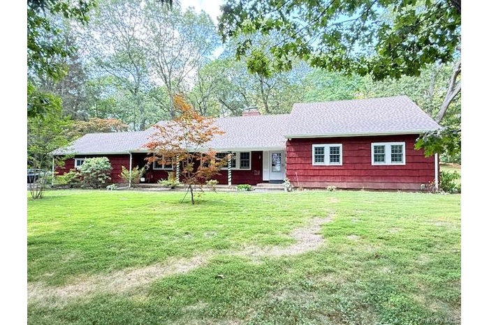 Single story home with a front lawn, a shingled roof, and a chimney