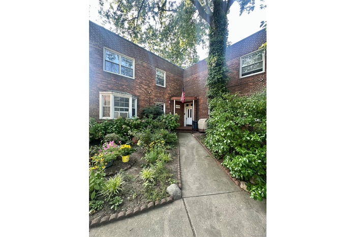Doorway to property with brick siding and garden