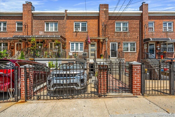Traditional home featuring a gate, brick siding, and a fenced front yard